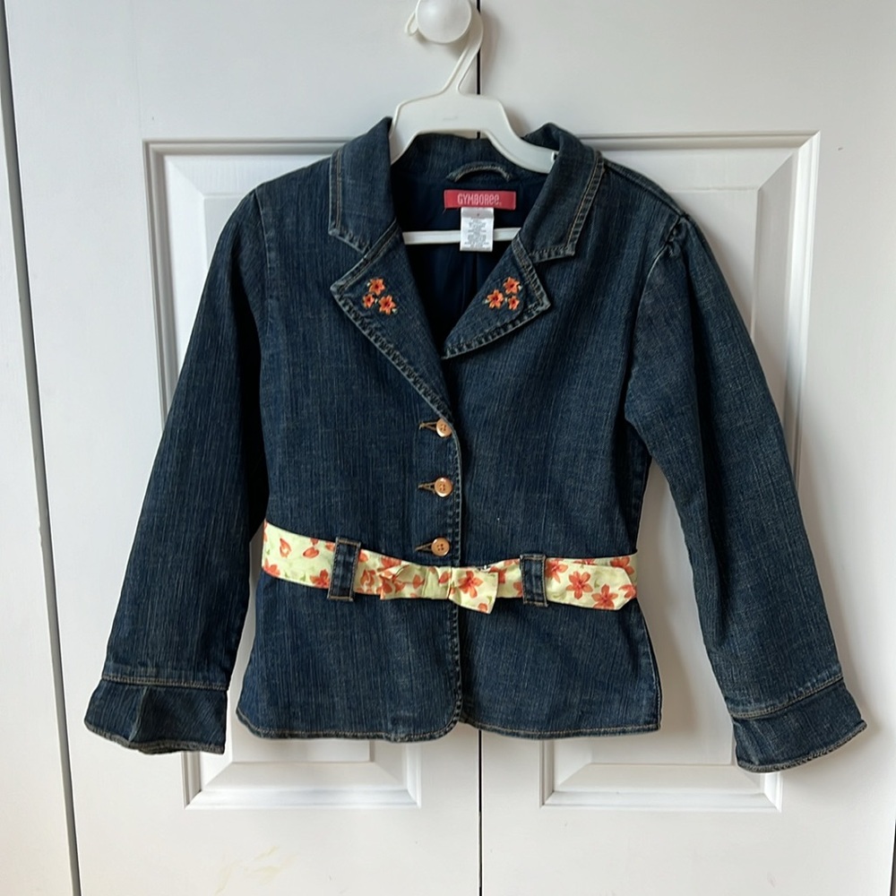 Girl’s jean jacket with floral embroidery and floral belt.